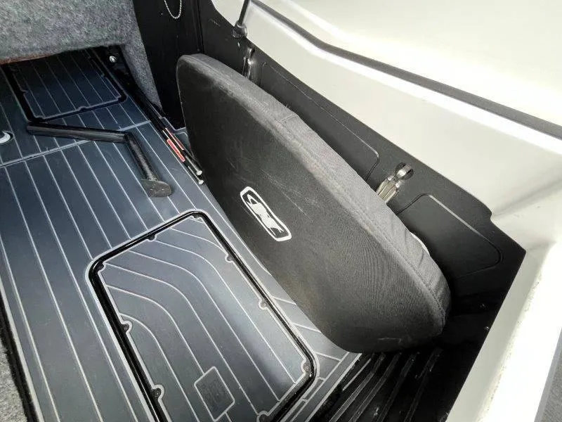 Slide: The Image of 2020 Nautique Paragon P25 interior storage compartment with black cover. - 25