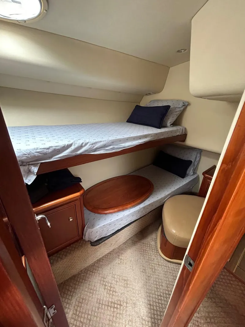 Slide: The Image of 2005 Riviera 37 Flybridge cabin with bunk beds and wooden furnishings. - 10