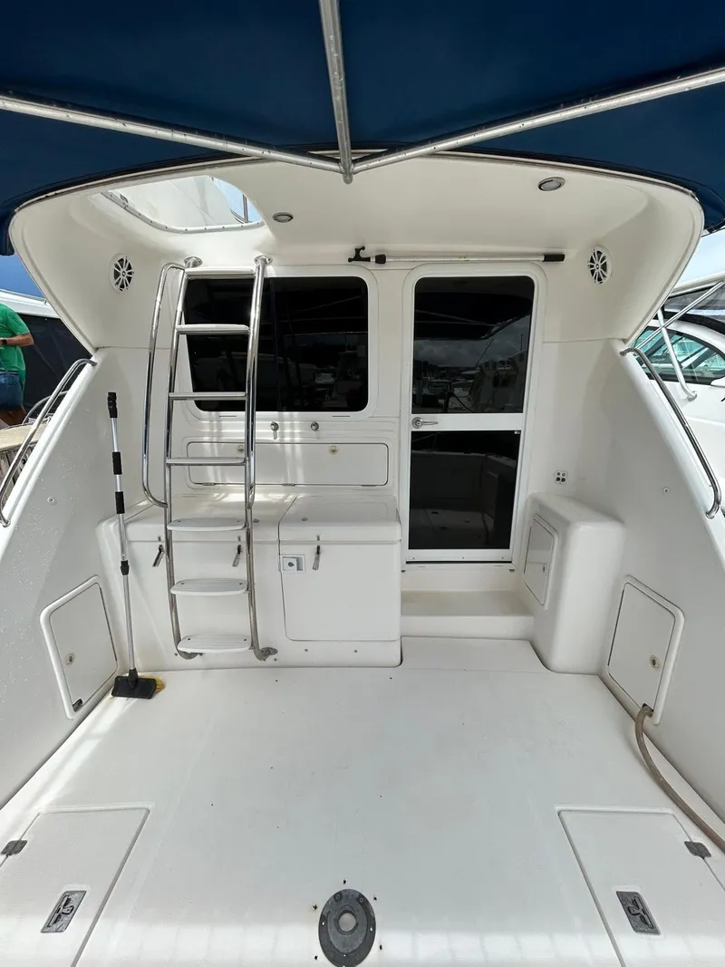 Slide: The Image of 2005 Riviera 37 Flybridge yacht with ladder and spacious deck under blue canopy. - 3