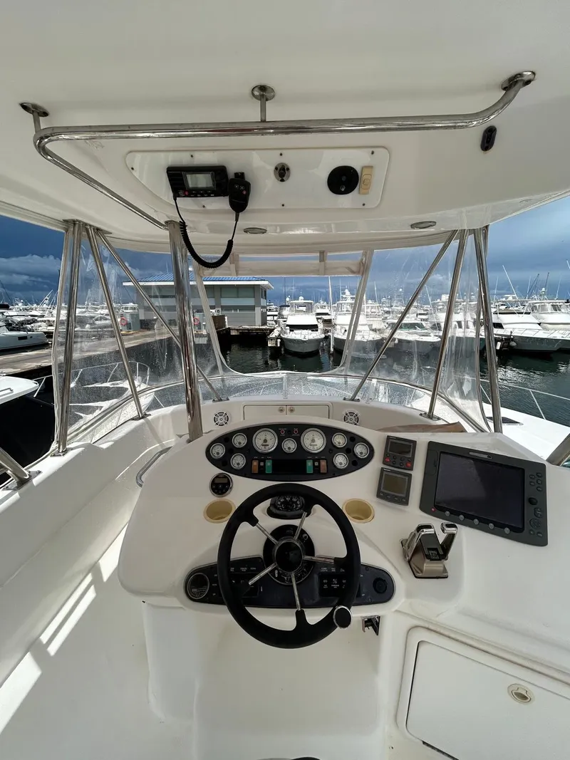 Slide: The Image of 2005 Riviera 37 Flybridge helm with marina view, featuring modern navigation equipment. - 4