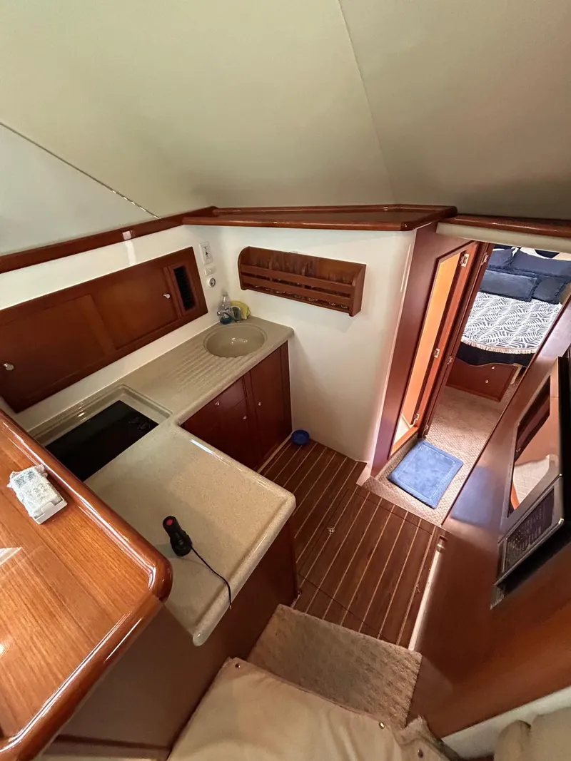Slide: The Image of 2005 Riviera 37 Flybridge yacht interior with kitchenette and wooden flooring. - 8