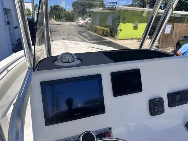 Slide: The Image of 2024 Key West 203 FS boat dashboard with navigation screens and compass. - 8