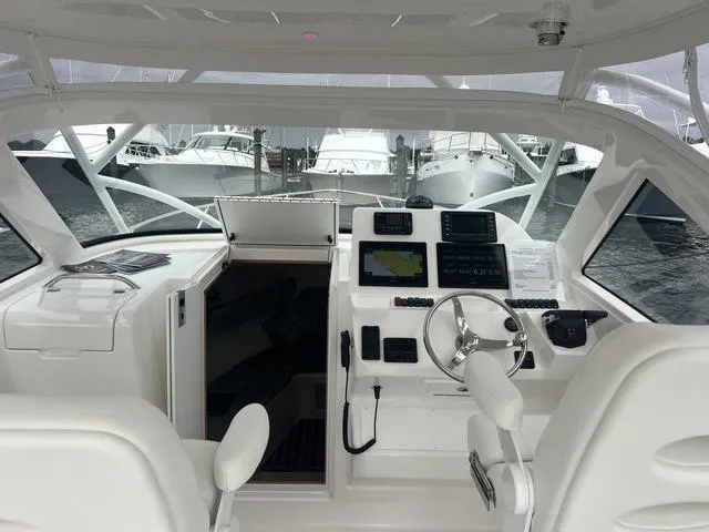 Slide: The Image of 2025 Albemarle 30 Express boat interior with modern navigation equipment and white seating. - 17