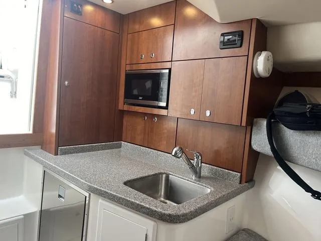 Slide: The Image of 2025 Albemarle 30 Express boat interior with modern kitchenette and wooden cabinetry. - 20