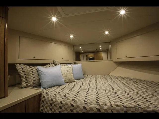 Slide: The Image of Luxurious cabin interior of 2024 Albemarle 41 Express yacht with cozy bedding and ambient lighting. - 25