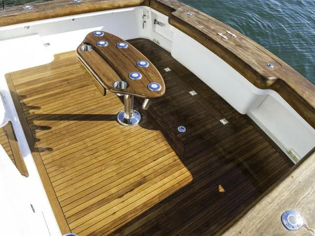 Slide: The Image of 2024 Albemarle 41 Express boat deck with wooden flooring and fishing rod holders. - 30