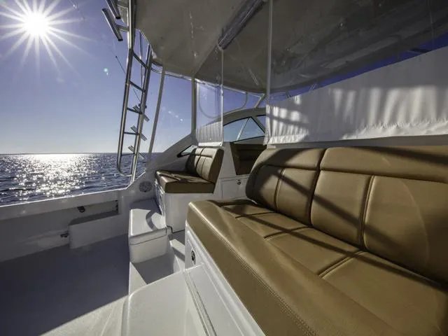 Slide: The Image of 2024 Albemarle 41 Express boat interior with tan seating, ocean view, and bright sun. - 6