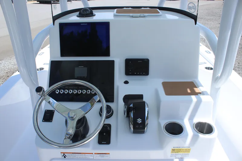 Slide: The Image of 2025 Sea Pro 250 Bay boat dashboard with steering wheel, controls, and cup holders. - 15