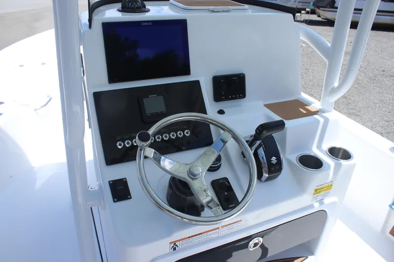 Slide: The Image of 2025 Sea Pro 250 Bay boat dashboard with steering wheel and electronic controls. - 16