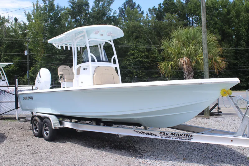 Slide: The Image of 2025 Sea Pro 250 Bay boat on trailer, parked outdoors with trees in background. - 2