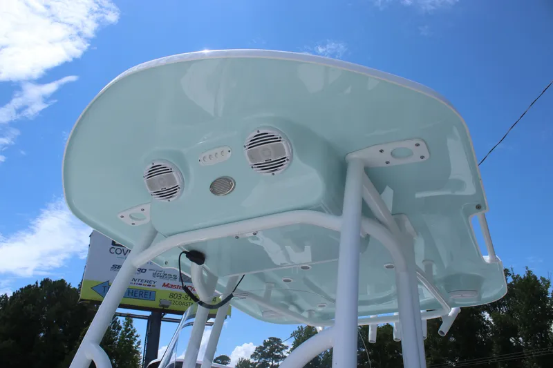 Slide: The Image of 2025 Sea Pro 250 Bay boat T-top with speakers against a clear blue sky. - 29