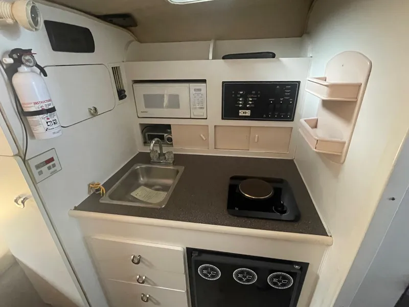 Slide: The Image of Compact kitchen in 1998 Rinker Fiesta Vee 280 boat with sink, stove, and microwave. - 10