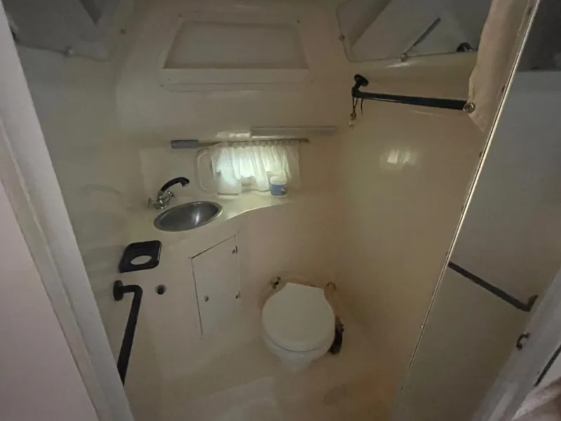 Slide: The Image of 1998 Rinker Fiesta Vee 280 boat bathroom with sink, toilet, and window. - 12