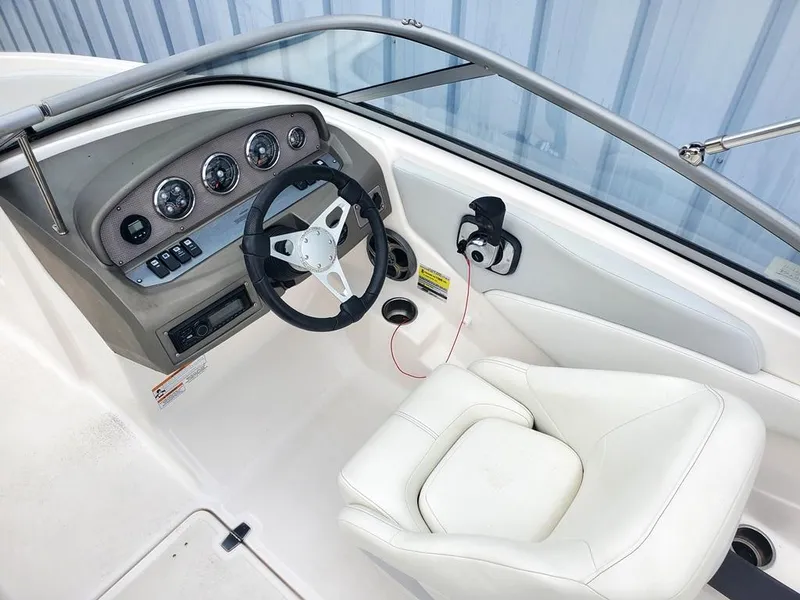 Slide: The Image of 2013 Regal 1900 BR boat cockpit with steering wheel and white seat. - 3