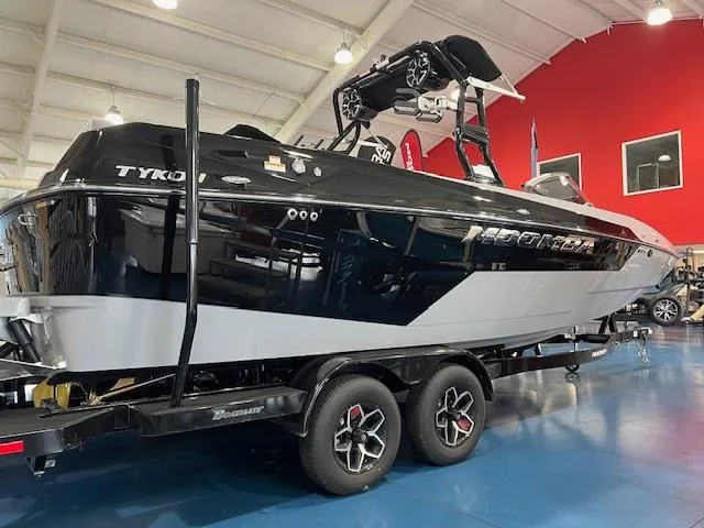 The Image of 2025 Moomba Tykon boat in showroom, black and white design, on trailer. - 1