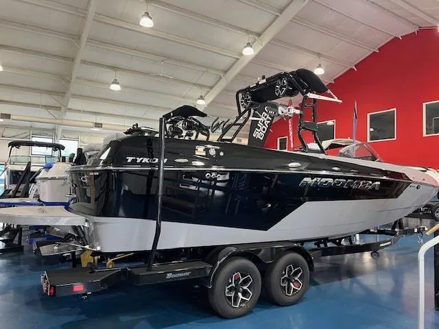 Slide: The Image of 2025 Moomba Tykon boat in showroom, black and white design, on trailer. - 4