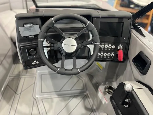 Slide: The Image of 2025 Moomba Tykon boat dashboard with steering wheel and control panel. - 8