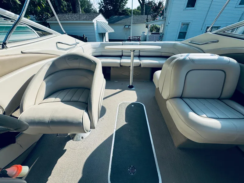 Slide: The Image of 1999 Maxum 230 boat interior with beige seating and carpeted floor. - 21