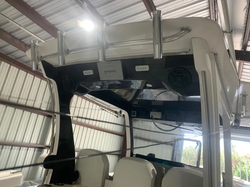 Slide: The Image of 2016 Edgewater 368 CC boat interior with rod holders and speakers in a metal shed. - 10