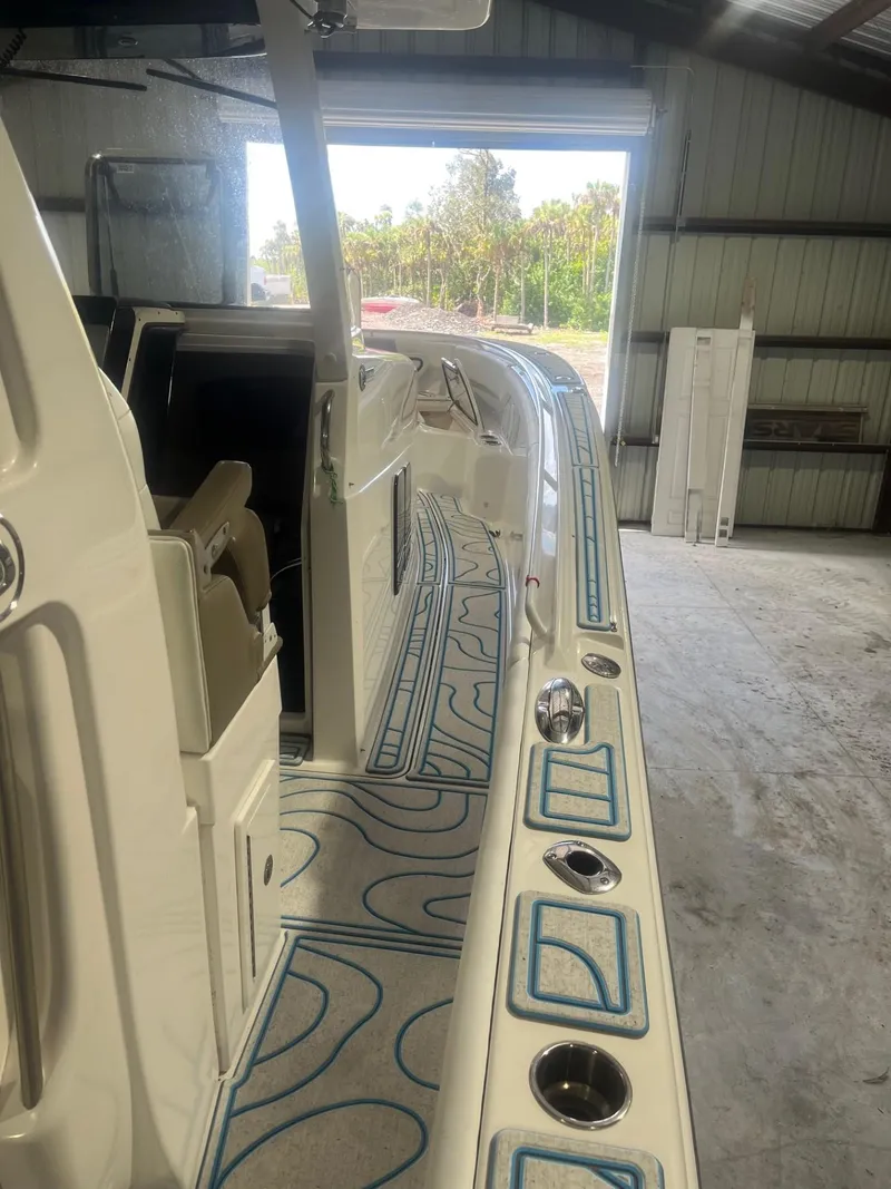 Slide: The Image of 2016 Edgewater 368 CC boat in storage, featuring detailed deck design and modern amenities. - 13