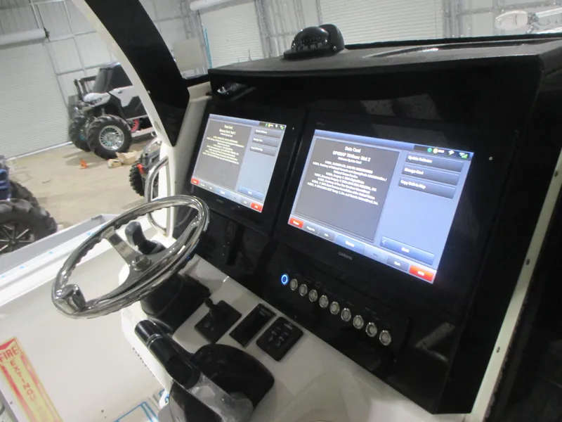 Slide: The Image of Edgewater 368 CC 2016 boat dashboard with dual screens and steering wheel. - 16