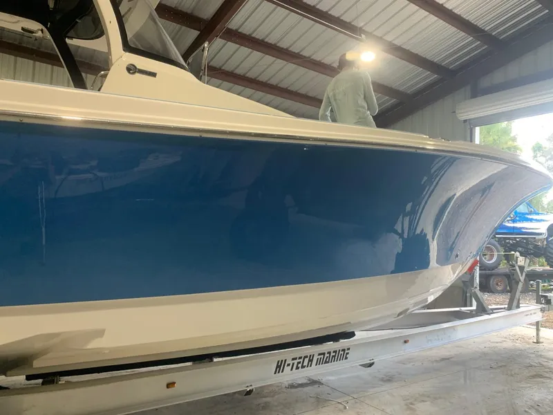 Slide: The Image of 2016 Edgewater 368 CC boat in storage, blue hull, on Hi-Tech Marine trailer. - 3