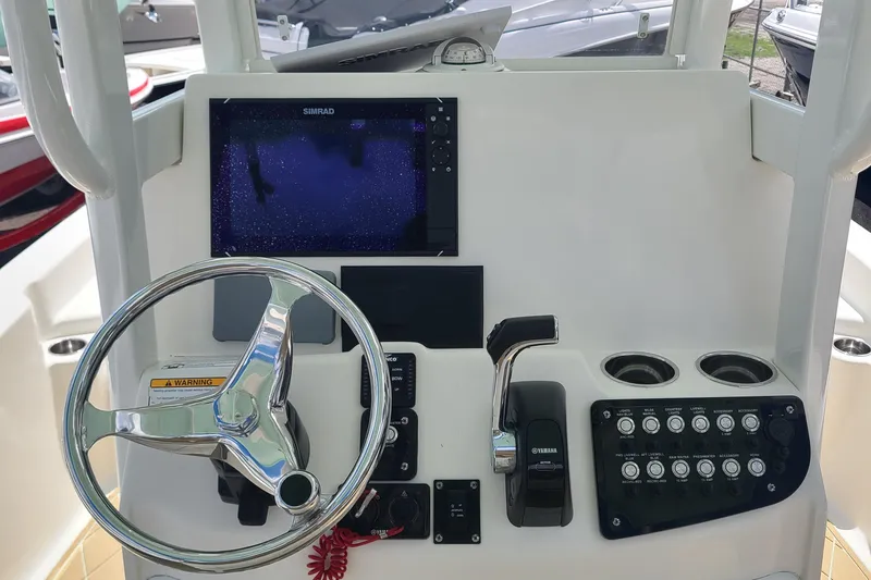Slide: The Image of 2018 NauticStar 265 XTS boat dashboard with steering wheel and control panel. - 13