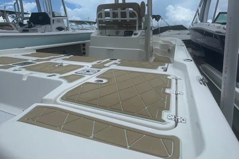 Slide: The Image of 2018 NauticStar 265 XTS boat deck with tan cushioned seating and storage compartments. - 3
