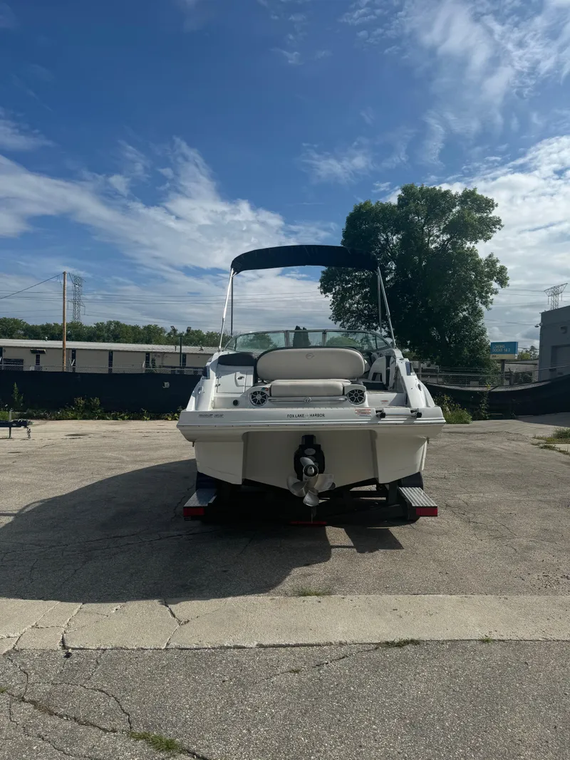 Slide: The Image of 2020 Crownline 255 SS boat parked outdoors under a blue sky. - 16