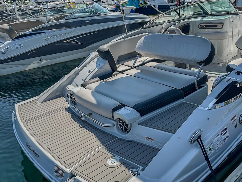 Slide: The Image of 2020 Crownline 255 SS boat with spacious seating and sleek design at a marina. - 3