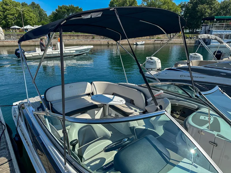 Slide: The Image of 2020 Crownline 255 SS boat docked, featuring spacious seating and canopy. - 4