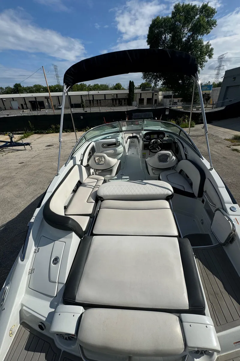 Slide: The Image of 2020 Crownline 255 SS boat with spacious seating and sunshade, docked outdoors. - 8