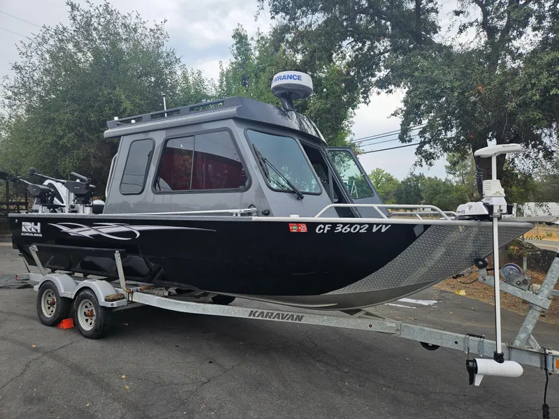 Slide: The Image of 2022 RH Boats 22 Coastal Hard Top on trailer, parked outdoors. - 2