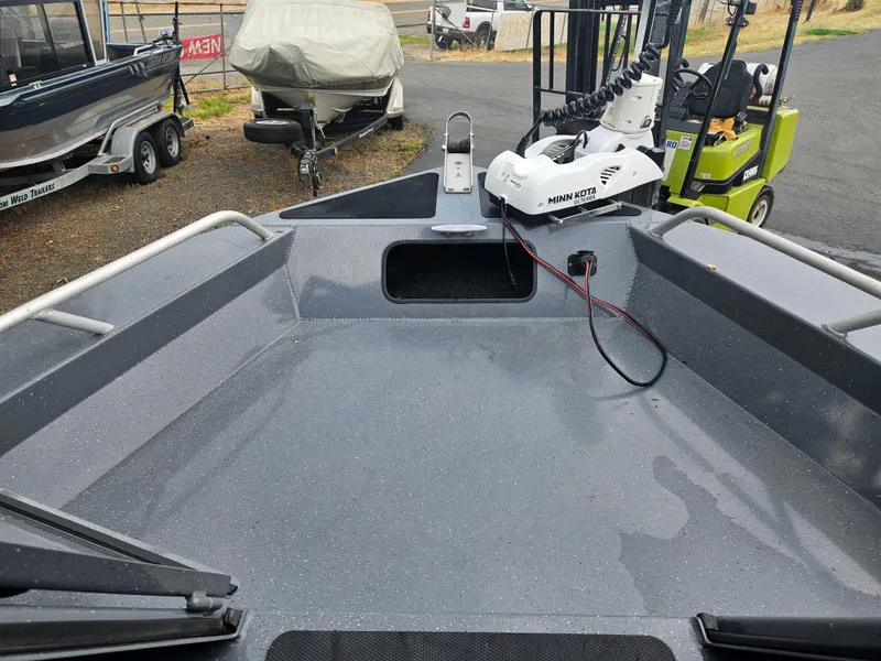 Slide: The Image of 2022 RH Boats 22 Coastal Hard Top deck with Minn Kota motor, parked outdoors. - 7