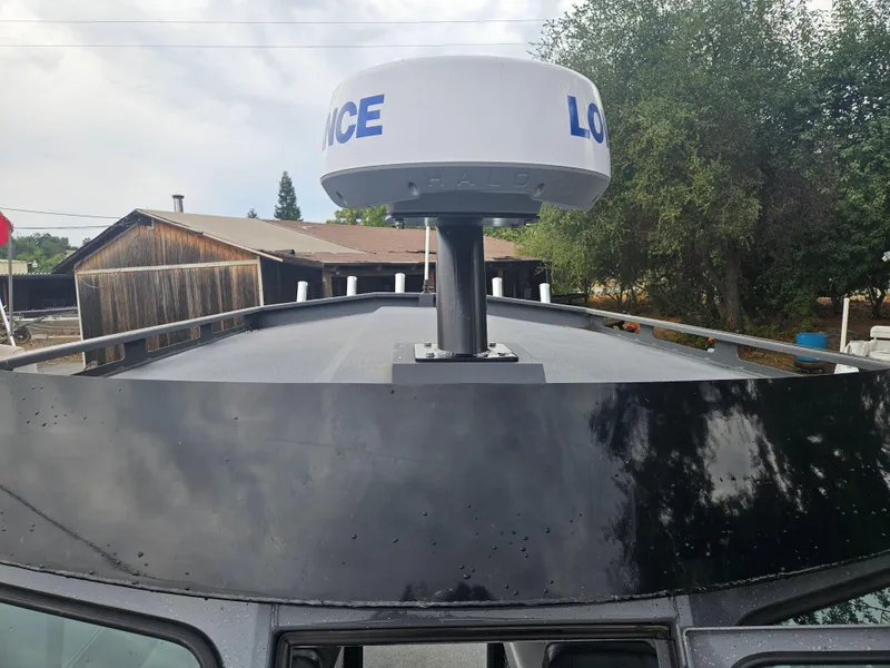 Slide: The Image of 2022 RH Boats 22 Coastal Hard Top with radar, docked near wooden buildings. - 8