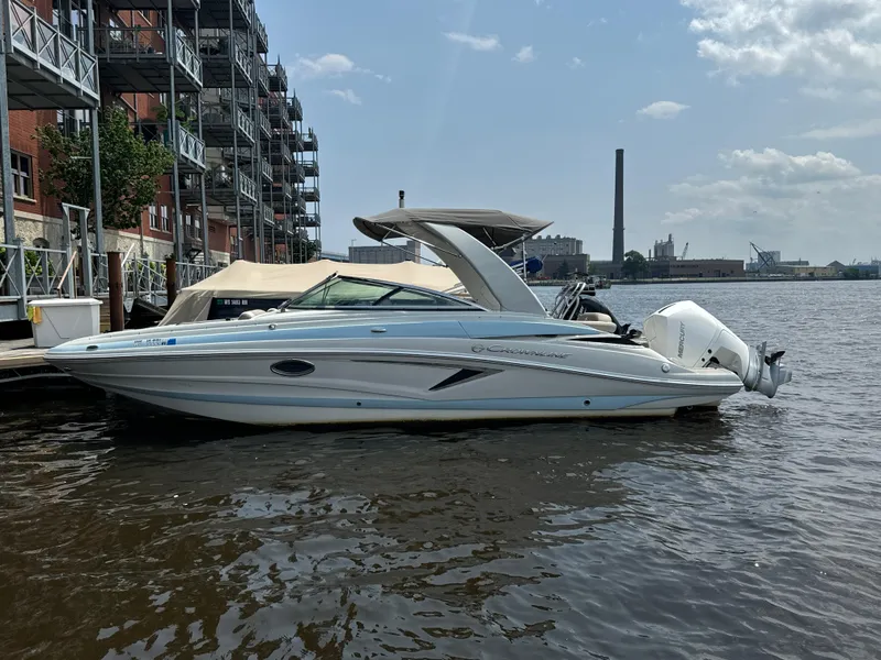 Slide: The Image of 2023 Crownline 255 XS boat docked by urban waterfront. - 1