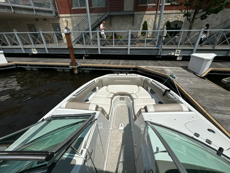 Slide: The Image of 2023 Crownline 255 XS boat docked at marina, featuring spacious seating and sleek design. - 13