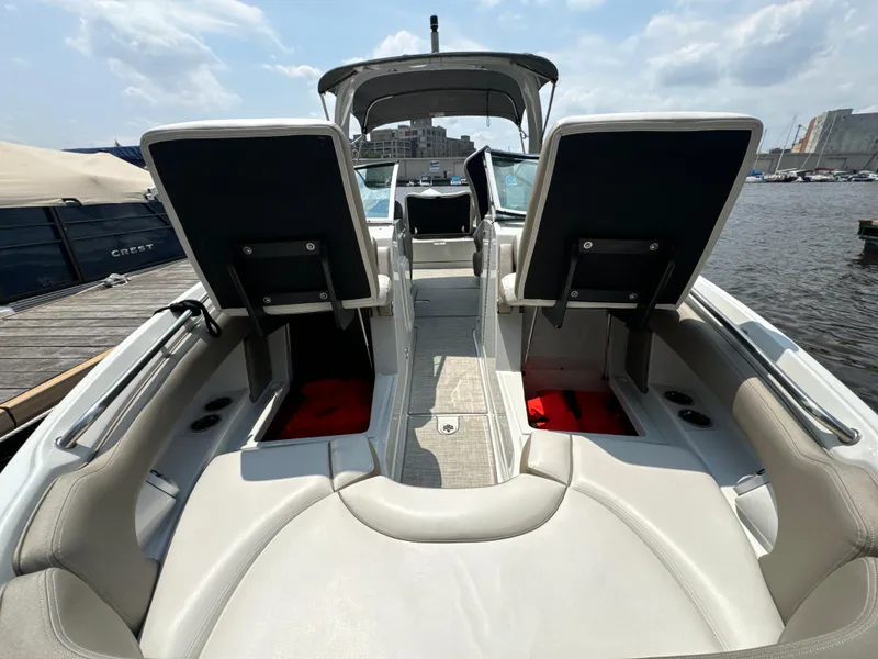 Slide: The Image of 2023 Crownline 255 XS boat interior with seating and open storage compartments. - 16