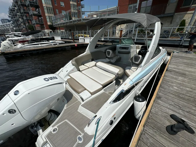 Slide: The Image of 2023 Crownline 255 XS boat docked at marina, featuring spacious seating and modern design. - 17