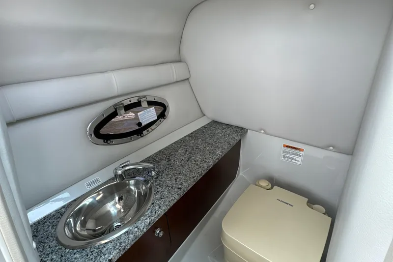 Slide: The Image of 2023 Crownline 255 XS boat interior with sink and portable toilet. - 18