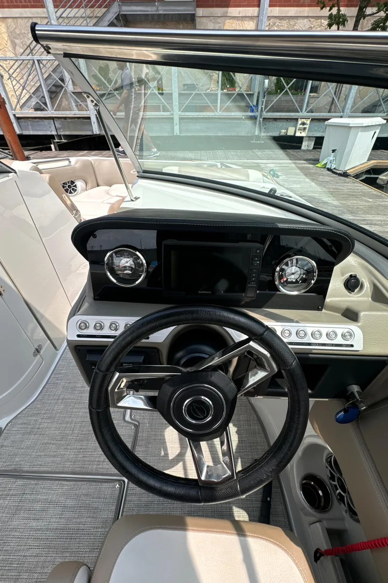 Slide: The Image of 2023 Crownline 255 XS boat dashboard with steering wheel and controls. - 19