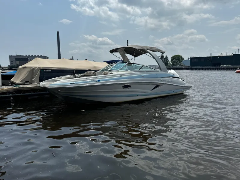 Slide: The Image of 2023 Crownline 255 XS boat docked on a sunny day. - 2