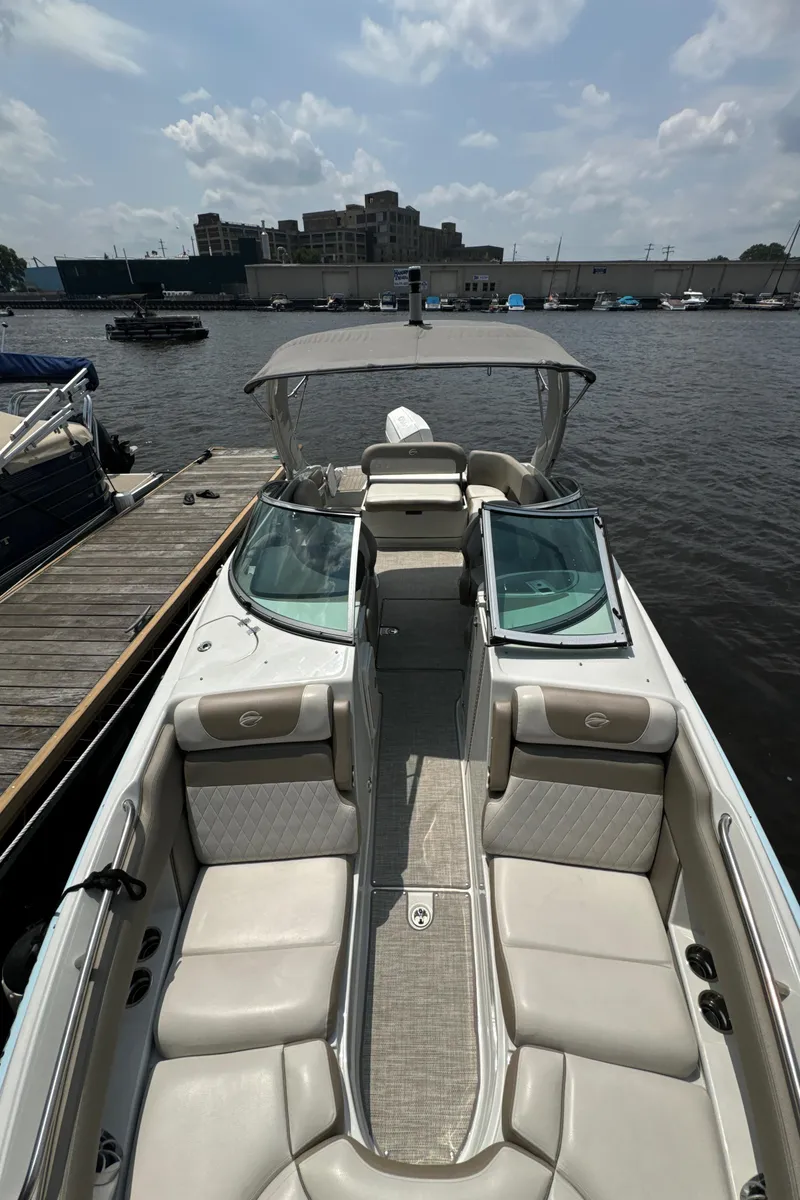 Slide: The Image of 2023 Crownline 255 XS boat docked at marina under cloudy sky. - 21