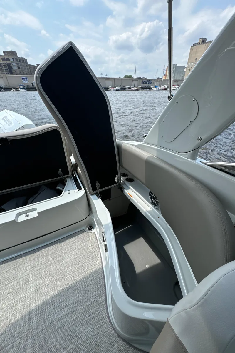 Slide: The Image of 2023 Crownline 255 XS boat interior storage compartment open by the waterfront. - 24