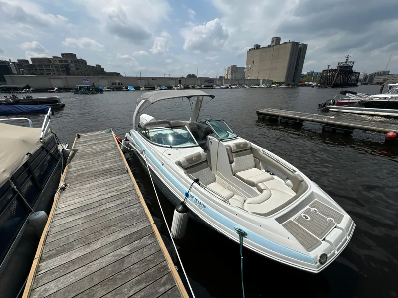 Slide: The Image of 2023 Crownline 255 XS boat docked at a marina under cloudy skies. - 5