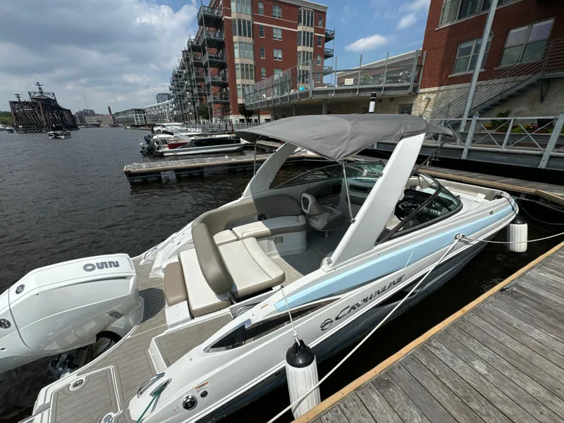Slide: The Image of 2023 Crownline 255 XS boat docked by waterfront buildings. - 9