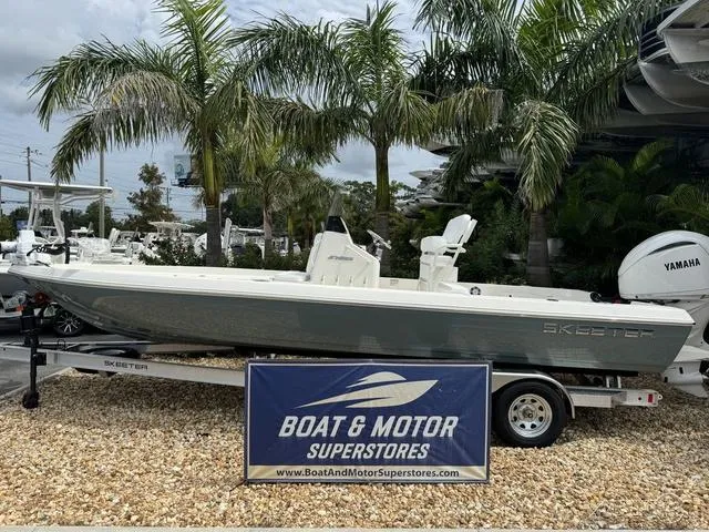 Slide: The Image of 2025 Skeeter SX230 boat on display at Boat & Motor Superstores, surrounded by palm trees. - 1
