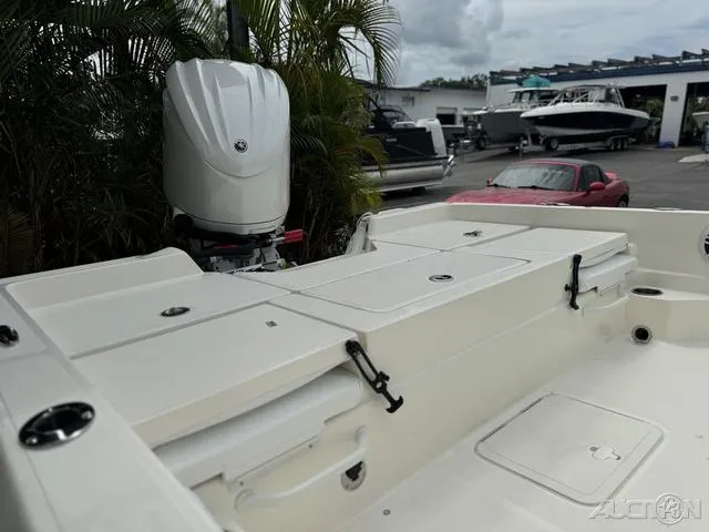 Slide: The Image of 2025 Skeeter SX230 boat with outboard motor, docked near palm trees. - 16