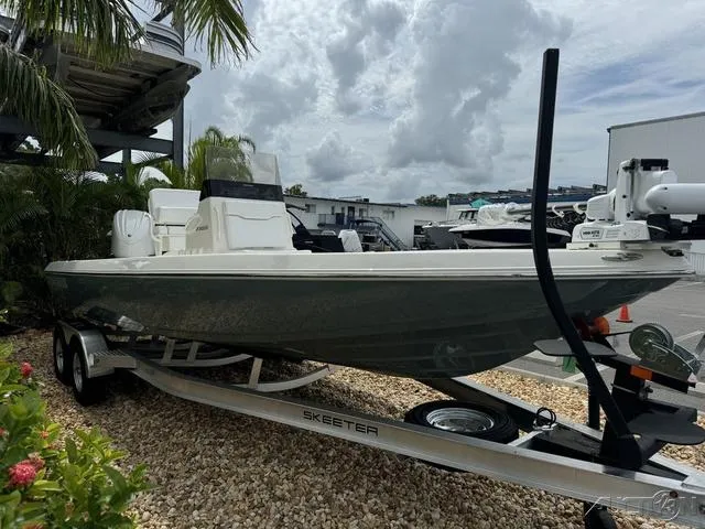 Slide: The Image of 2025 Skeeter SX230 boat on trailer, parked outdoors under cloudy sky. - 7