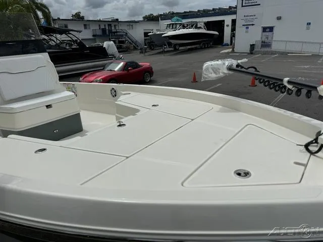 Slide: The Image of 2025 Skeeter SX230 boat deck in marina, with other boats and a red car nearby. - 8